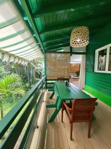 una mesa verde en la terraza de una casa en Villa Celiane, en Petit-Bourg