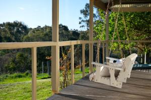 The Cottage at Lake Werona في Werona: أرجوحة على شرفة المنزل +6 صور