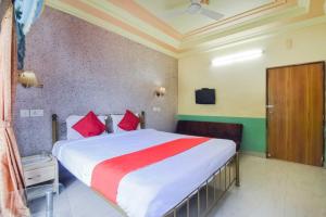 a bedroom with a large bed with red pillows at Hotel O Ritz Rivera in Kolkata