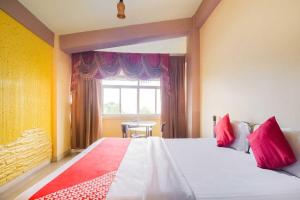 a bedroom with a bed and a window and a table at Hotel O Ritz Rivera in Kolkata +14 photos