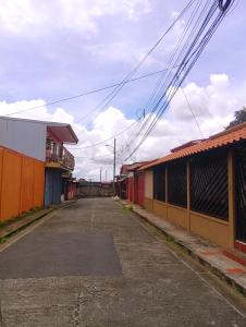 an empty street in a town with buildings at Casa de descanso in Alajuela City