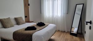 a bedroom with a bed with two black towels on it at The Frenchie's House in Rabo de Peixe