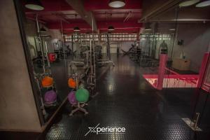 Una habitación con gimnasio y equipamiento. en Gold Rabbit at 26, City Views and Wonderland Vibes!, en Hatillo