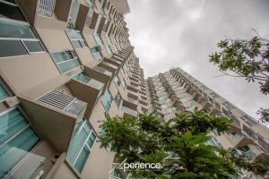 Un edificio alto con árboles delante. en Gold Rabbit at 26, City Views and Wonderland Vibes!, en Hatillo