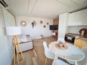 una cucina e un soggiorno con tavolo e sedie di Appartement La Pergola a La Grande-Motte