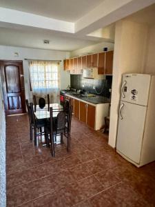 a kitchen with a table and a white refrigerator at desertico in Neuquén