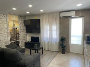 a living room with a couch and a table and a window at Apartamento Paula in Valladolid