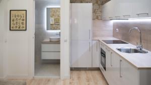 a kitchen with white cabinets and a sink at Apartamento Preciados in Madrid +5 photos