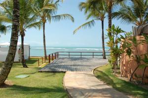 a walkway leading to the beach with palm trees at Casa5 in Arraial d'Ajuda