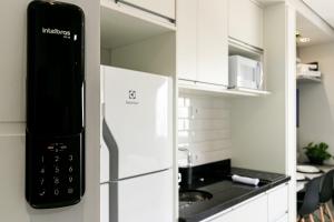 a kitchen with a refrigerator with a microwave at Apê no Belenzinho – Metrô Bresser / Pq. Belém in Sao Paulo
