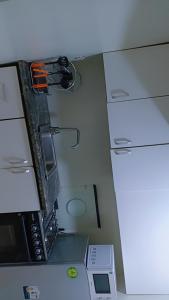 a kitchen with a stove and a microwave at Vickie's Home in Lagos