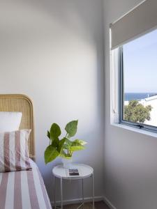 una camera da letto con una pianta su un tavolo accanto a una finestra di Castaways Penthouse Noosa, Beachfront Pool Tennis a Castaways Beach