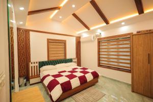 a bedroom with a bed with a checkered blanket at Wayanadan Huts Homestay in Sultan Bathery