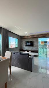a living room with a couch and a tv at Conforto & Sofisticação in Macapá +14 photos