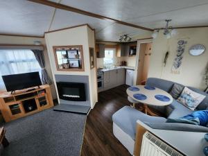 a living room with a couch and a table at 92 Barmouth Bay Holiday Park in Llanddwywe
