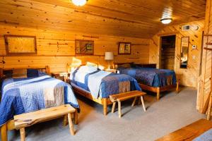 a bedroom with two beds in a log cabin at Spruces at Pine Cone Lodge- Big Sand Lake in Park Rapids