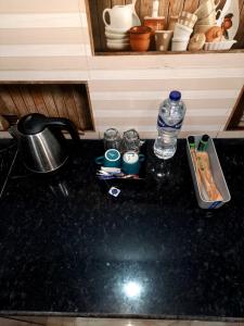 een aanrechtblad met daarop een waterfles en glazen bij The Moksha Residency By MOM'S in Prayagraj