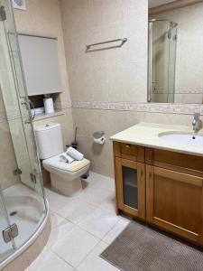 a bathroom with a toilet and a sink and a shower at Mãos n'Areia in Ferrel +8 photos
