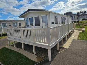 a large white mobile home with a porch at Reighton Sands Holiday Park - Holiday Accommodation 20923 in Reighton