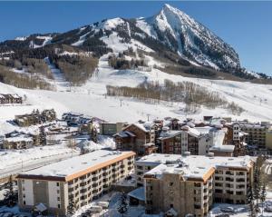 a resort in the snow with a mountain in the background at Walk to Mountain Base Studio for 4 & POOL in Crested Butte