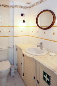 a bathroom with a sink and a toilet and a mirror at Casa do Poço in Faro