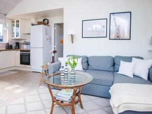 a living room with a blue couch and a table at Secluded Haven in Kelstrup - By Traum Ferienwohnungen in Kelstrup Strand