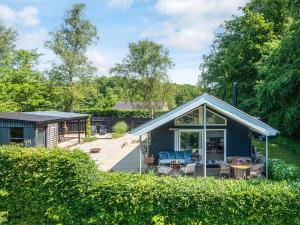 a blue cottage with a deck and a patio at Secluded Haven in Kelstrup - By Traum Ferienwohnungen in Kelstrup Strand