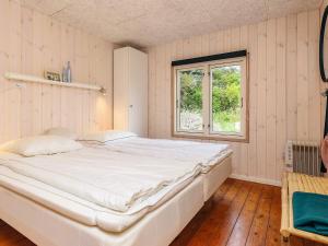 a large white bed in a room with a window at 4 person holiday home in Hjørring-By Traum in Lønstrup