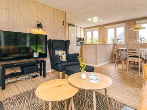 a living room with a large television and a table at 4 person holiday home in Hjørring-By Traum in Lønstrup