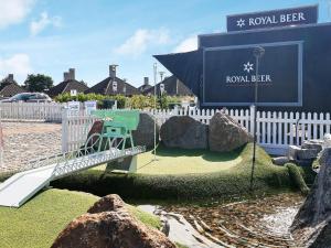 a garden with a playground with a swing and an umbrella at 3 room in holiday park in Karrebæksminde in Karrebæksminde