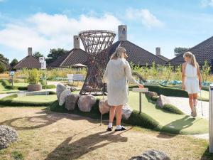 two women are looking at a sculpture in a garden at 3 room in holiday park in Karrebæksminde in Karrebæksminde +52 photos