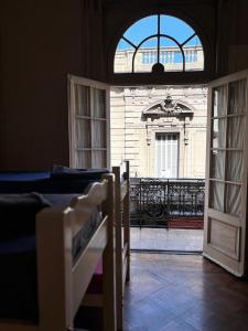 an open door to a building with a balcony at Colmena Hostel Rosario in Rosario +15 photos