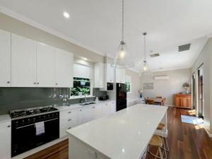 a kitchen with white cabinets and a white counter top at Classic Meets Modern in Central Wagga in Wagga Wagga