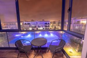 a balcony with a table and chairs and a pool at Modern apartment with pool view Tamaris in Tamaris