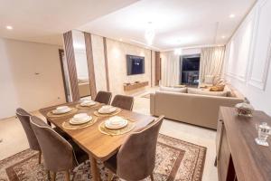 a living room with a table and chairs and a couch at Modern apartment with pool view Tamaris in Tamaris