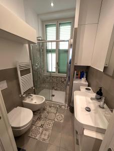 a bathroom with two sinks and a toilet and a shower at Nuovo Appartamento Borgo Coscia in Alassio