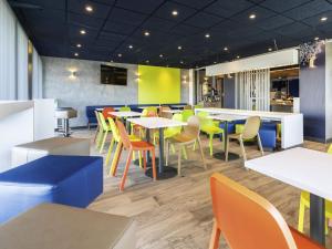 a dining room with tables and chairs in a restaurant at ibis budget Rennes Rte Lorient in Rennes
