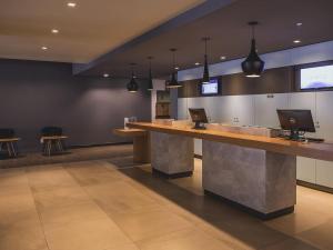 a lobby with a counter with two computers on it at ibis Carlos Barbosa in Carlos Barbosa