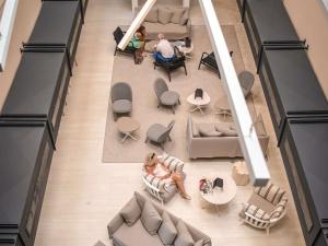 an overhead view of a lobby with people sitting in chairs and tables at Mercure Hotel & Spa Bastia Biguglia in Biguglia