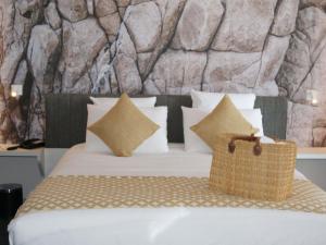 a bed with pillows and a basket on top of it at Mercure Hotel & Spa Bastia Biguglia in Biguglia +111 photos