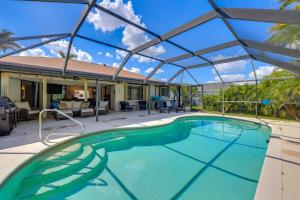 a swimming pool with a canopy over a house at Punta Gorda Vacation Rental with Heated Pool and Lanai in Punta Gorda