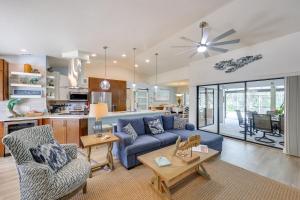 a living room with a blue couch and a kitchen at Punta Gorda Vacation Rental with Heated Pool and Lanai in Punta Gorda
