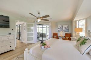 a bedroom with a large white bed with a fan at Punta Gorda Vacation Rental with Heated Pool and Lanai in Punta Gorda