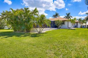 a yard with palm trees and a house at Punta Gorda Vacation Rental with Heated Pool and Lanai in Punta Gorda