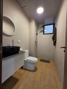 a bathroom with a toilet and a sink and a mirror at Noah Luxury Airport Drive Gated Apartment in Addis Ababa