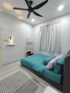 a bed in a room with a ceiling fan at De Suria Homestay Jitra in Jitra