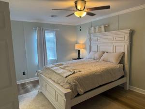 a bedroom with a large bed with a ceiling fan at Friendly Home Near Downtown & UL - Fenced Yard in Lafayette