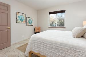 a white bedroom with a large bed and a window at Serendipity Retreat - Dogs Welcome Farm Tours and Private Yoga Sessions in Atascadero
