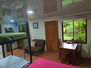 a room with a bed and a desk and a table at Granja Agua Azul, Wi-FI,AC-WC,Parking,la Fortuna in Fortuna +42 photos