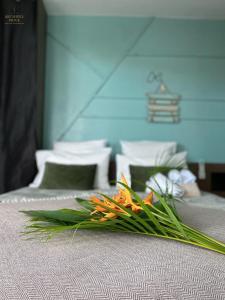 a bouquet of flowers sitting on top of a bed at Archipel Guadeloupéen - Entre grand balcon, piscine & lagon - Élégant cocon d'architecte 2 étoiles in Saint-François